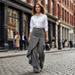 Asymmetrische wrap jeans 👖 Een combinatie van culottes en een pantalon, met een hoge taille voor een optisch langer lijkend effect, wijde pijpen en een zwierige pasvorm, en diagonaal geplaatste knopen – transformeer jezelf direct in een fashionista! ✨